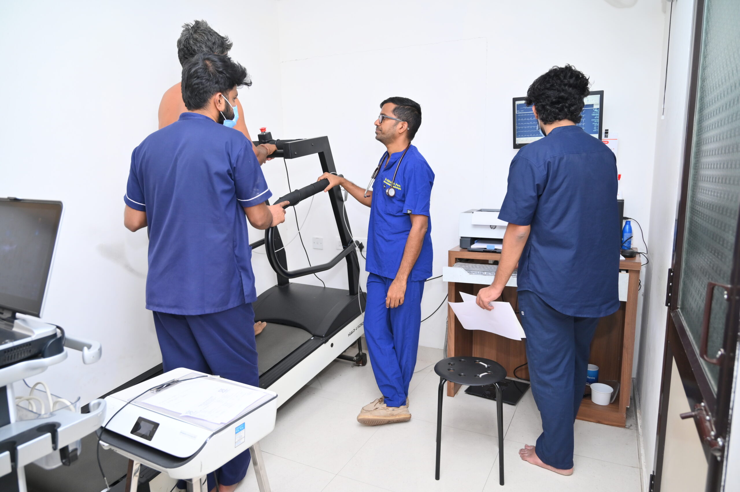 Medical team operating treadmill stress test